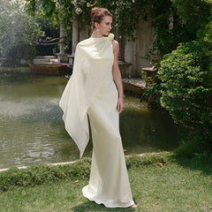 Women wearing a apricot satin gown with flowing streamers in a garden setting