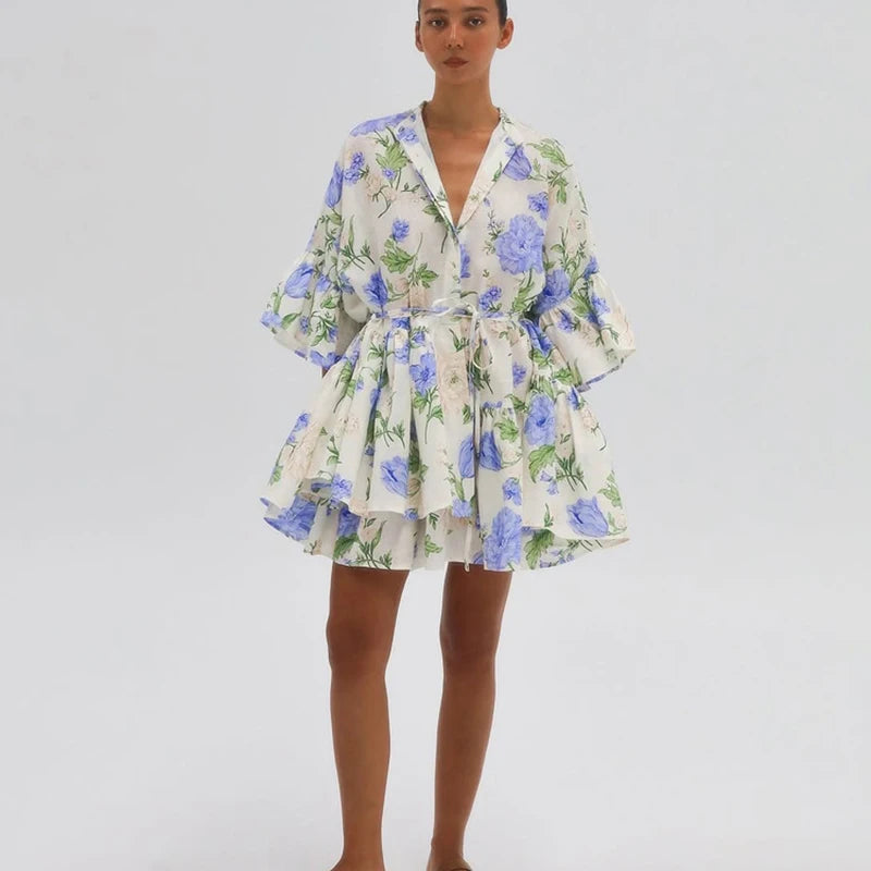 Woman wearing an elegant long-sleeve mini dress in blue and beige for work or weekend on a plain background.