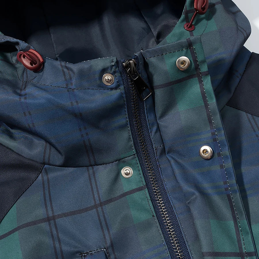 Close-up of a blue and green plaid jacket with buttons and zipper