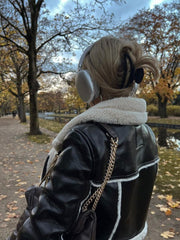 Back side view of a woman wearing a Double-Sided Short Jacket Warm Thick Lapel Lambswool Coat, walking in a park with headphones in her ear.