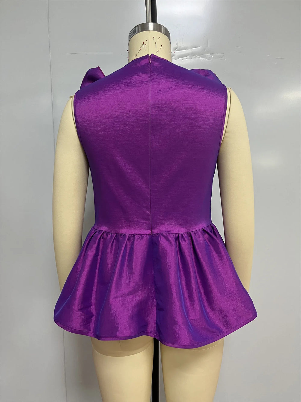 Purple dress on a mannequin against a plain background
