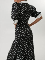 Back view of black polka dot dress with puff sleeves and curve fit