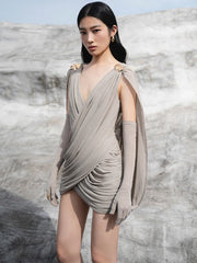 Three-quarter view highlighting the cape sleeve fall and clean mini hemline, styled for an elevated cocktail look with minimal accessories.