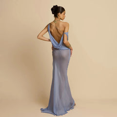Woman wearing a backless formal mesh maxi dress for women at an evening gala  with an open back against a beige background