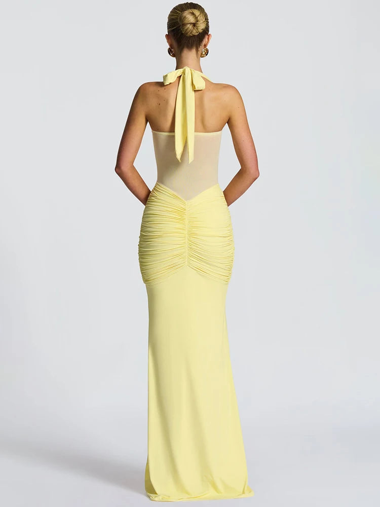 Backless yellow gown with slim silhouette and halter neckline