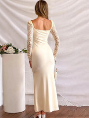 Backless ivory dress styled with heels and minimalist clutch