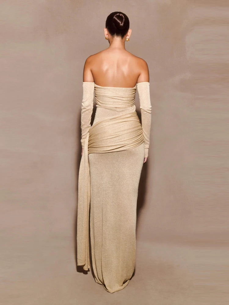 Back side of a woman wearing an elegant sculpted gown with full-length sleeves against a plain background 