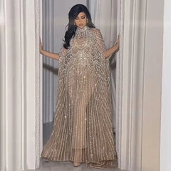 Woman in a sparkling gold dress standing in a doorway.