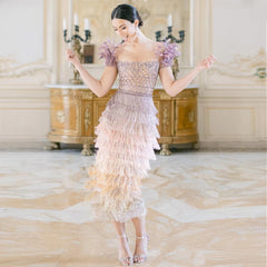 A close-up of the beaded mermaid dress, showing the intricate tassel and feather details.