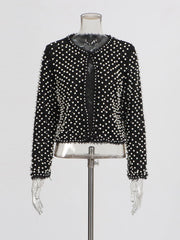 Detail view of the jacket sleeve highlighting structured drape and intricate beadwork.