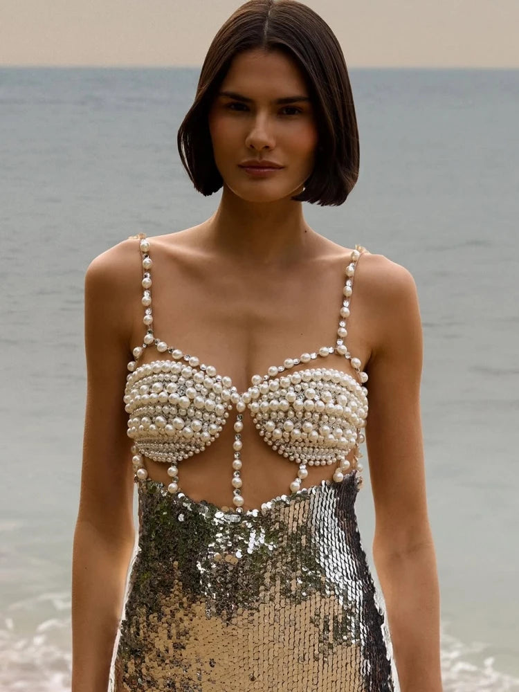 Close-up of the silver dress bodice highlighting beadwork, sequins, and the V-neckline finish.