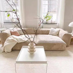 “Beige 3-seater sectional sofa with minimalist design in bright room”

