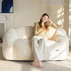 “Beige faux fur lounge chair in modern bedroom reading corner”

