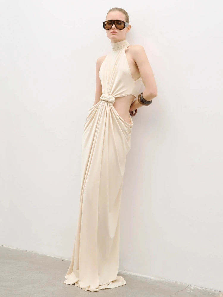Close-up of the waist twist-knot and front cut-out detail on a beige maxi dress, showing gathered fabric and clean finishing.