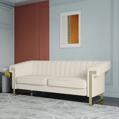 A beige velvet long couch Chesterfield sofa with a chaise, displayed in a room with a grey wall and a framed abstract picture above it.