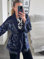Person wearing a blue patterned kimono-style garment in a bedroom setting.