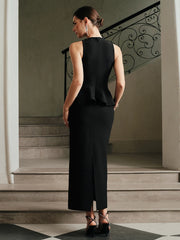 Side-angled pose shows the ankle-grazing hem and clean sleeveless cut, creating a long, structured silhouette with minimal accessories.