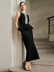 Full-length view highlights the sculpted sheath fit and peplum-like waist detail, finished with a crystal neckline for a polished evening look.