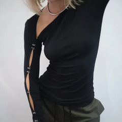 Close view of the sleeve cutout detailing on a black fitted top, highlighting the hollow design and streamlined arm shape.