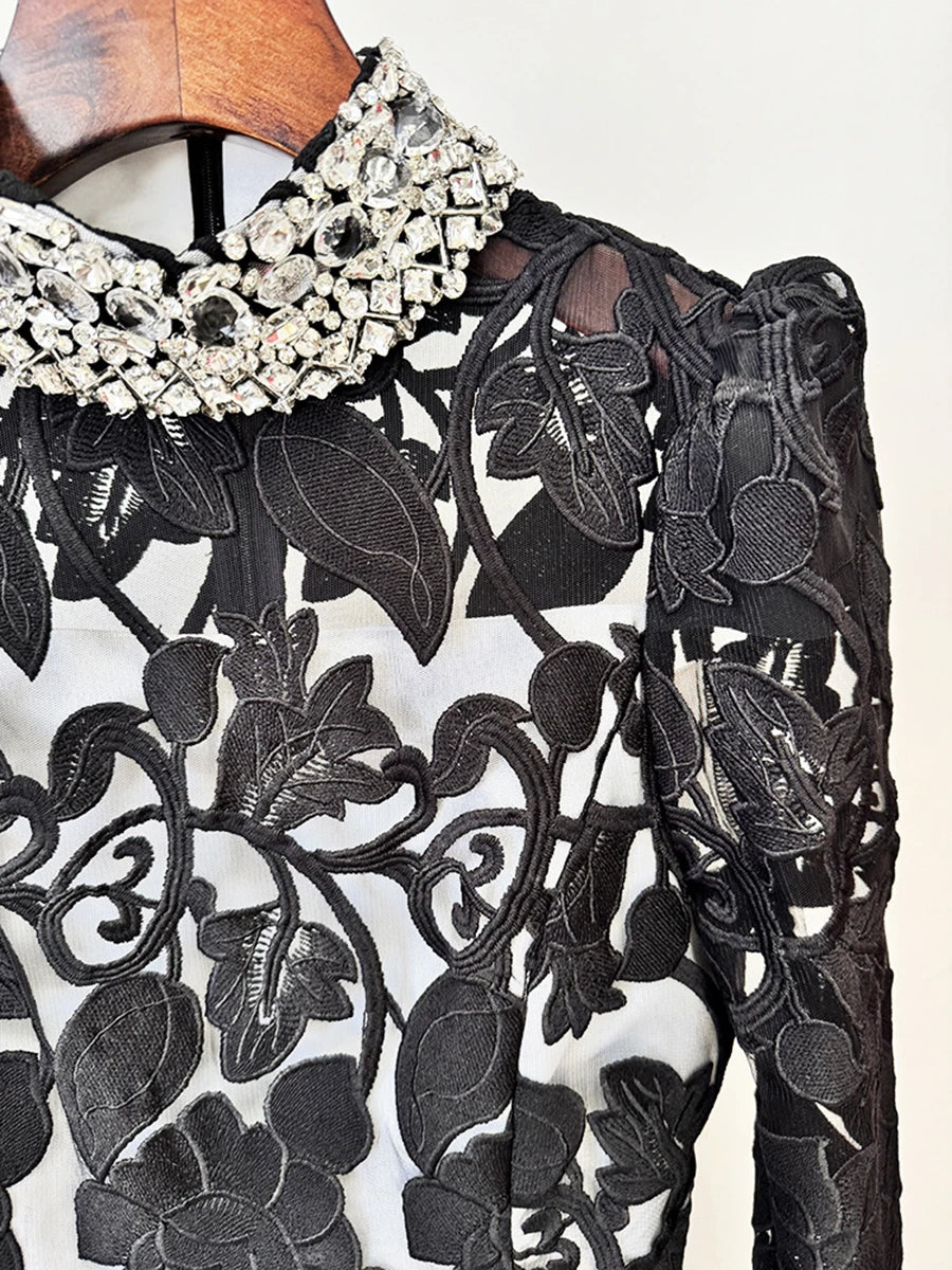 Lower skirt drape of the black maxi dress showing the A-line volume and lace-like texture that catches light in movement.