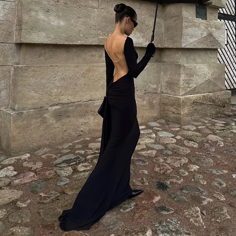 Lower-body view showing the black mermaid hem pooling softly on stone steps, emphasizing the dramatic floor-length finish and sleek drape.