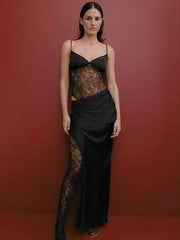 Woman wearing a  black lace backless maxi party dress styled for formal evening against a red background