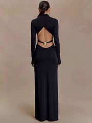 Woman wearing a black open-back long sleeve maxi dress against beige backdrop