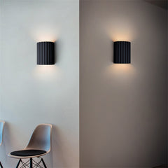 Painted black resin modern wall light used as a bedroom bedside lamp