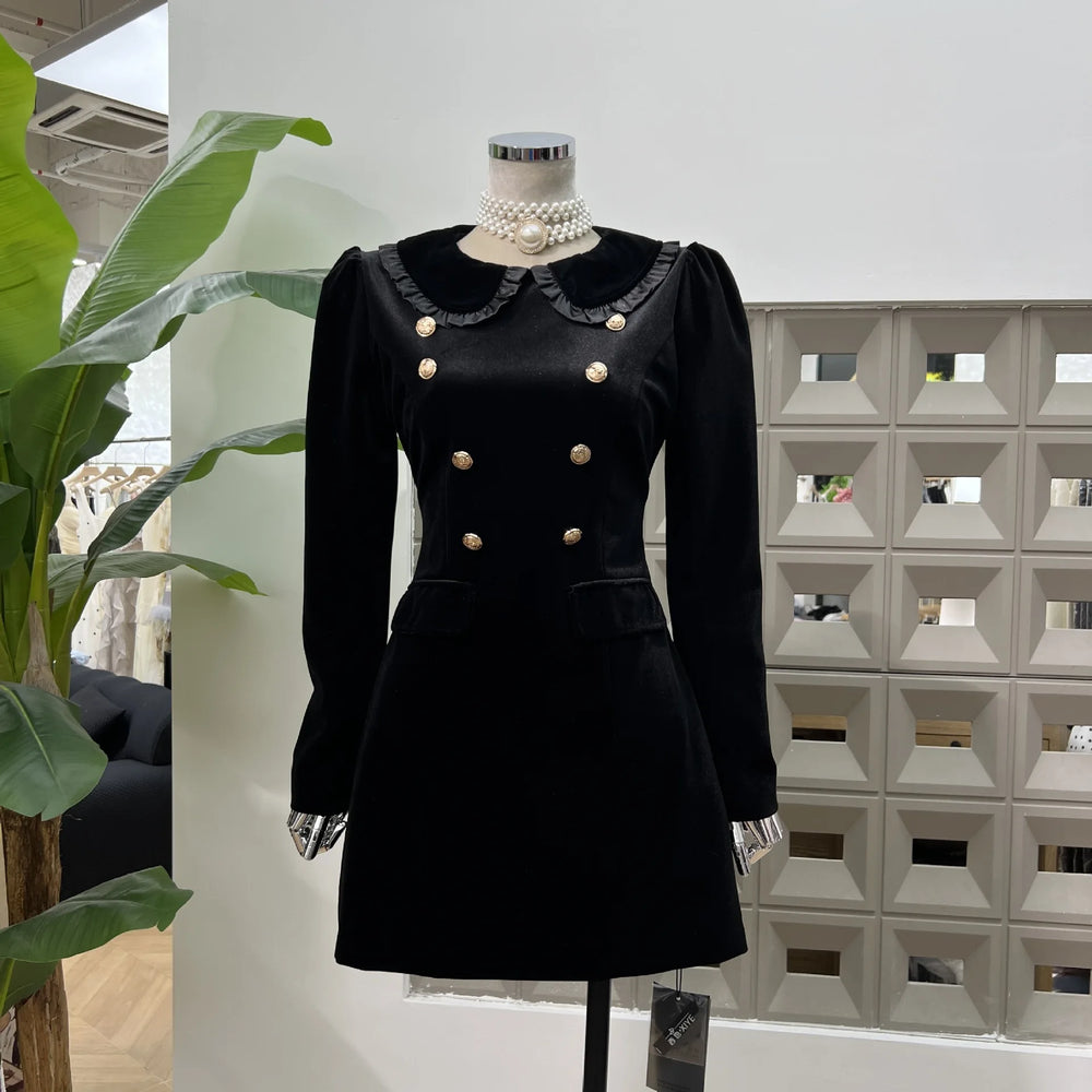 Black Peter Pan collar dress with gold-tone buttons on a mannequin