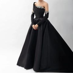 Black satin crystal one-shoulder evening gown styled for luxury parties with embellishments on a white background