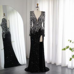 A woman modeling a black sequin mermaid gown with long sleeves and a V-neckline.