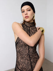 Three-quarter pose showing the long lace skirt drape and subtle transparency, styled for a modern, editorial night-out mood.