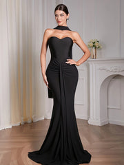 Woman wearing black strapless draped maxi dress in elegant indoor setting