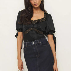 Close-up of black satin blouse featuring delicate lace trim