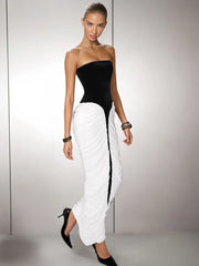 Woman wearing a  bodycon formal dress with a contrast panel and sculpted fit with a grey background