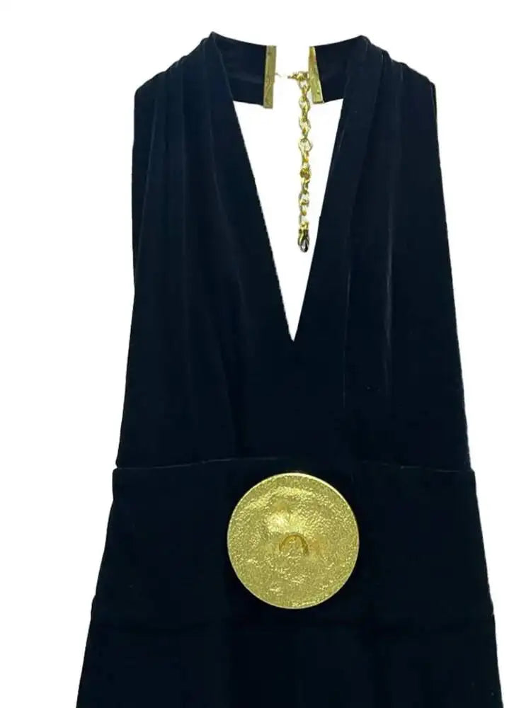 Minimal black wide-leg jumpsuit with statement gold accessories