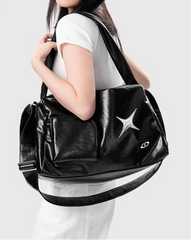 Black Y2K tote bag with white star motif, worn over the shoulder