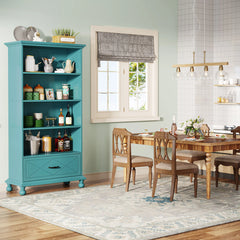 Modern living room with tall blue bookshelf styled with books and plants

