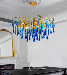 Blue crystal vine chandelier hanging above gold dining table set