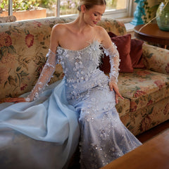 A close-up of the delicate 3D flowers and feather details on the dress.