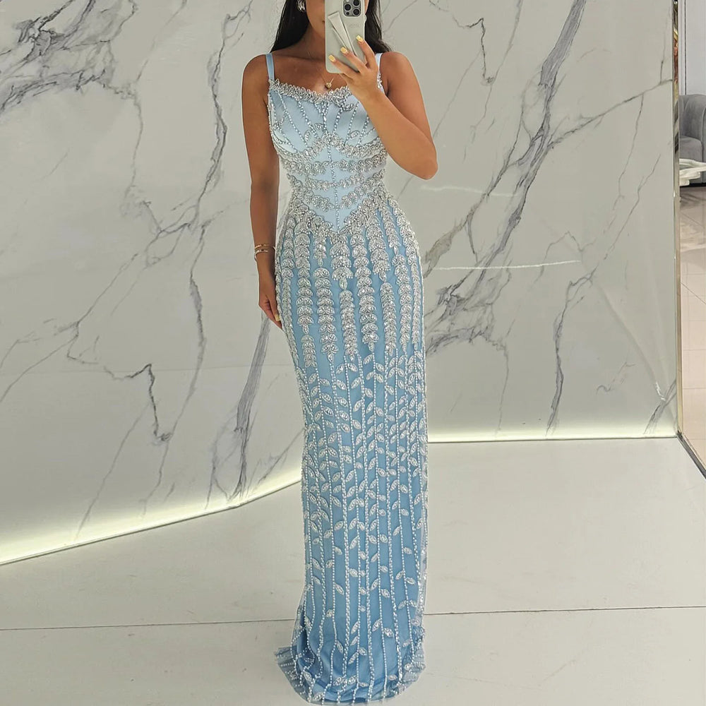 A woman wearing a blue spaghetti strap evening gown for a formal event.