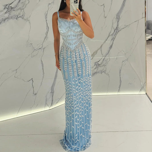 A woman wearing a blue spaghetti strap evening gown for a formal event.