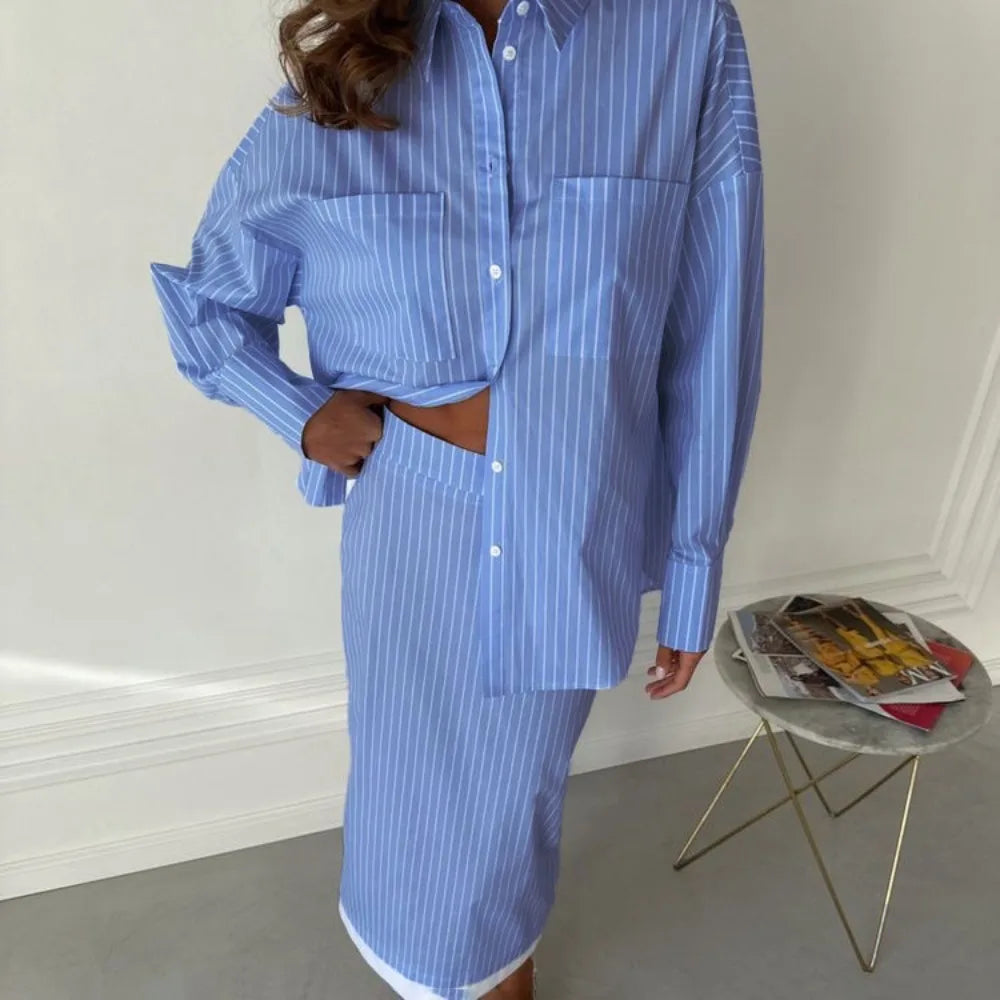 Person wearing a blue striped shirt and skirt set styled for minimalist workwear set in a minimalistic room.