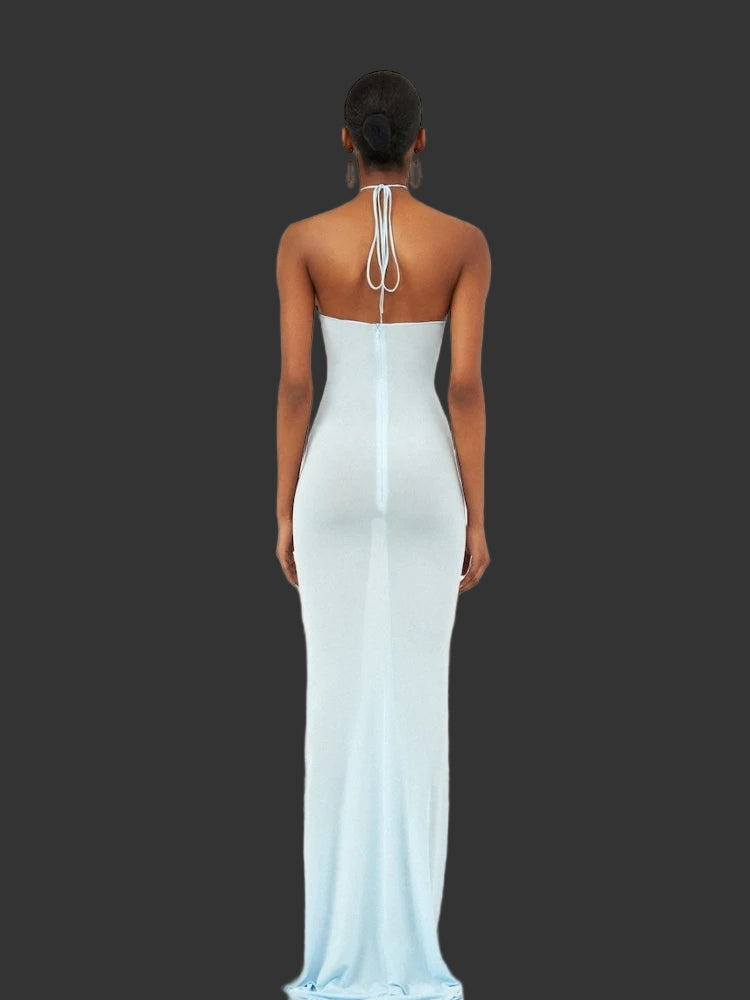 Bodycon party gown with blue floral applique for juniors. Woman wearing a light blue evening gown with a halter neck design on a white background