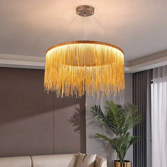 A gold and ivory tassel chain chandelier hanging in a room with a living space in the background.