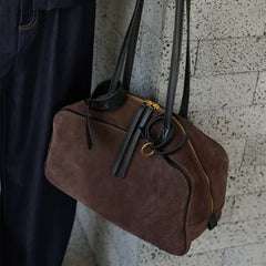 Suede-finish leather handbag shown carried on the shoulder with a structured profile