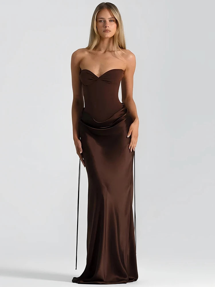 Woman wearing a brown satin strapless maxi dress on a white background