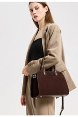Styled shot of a brown suede leather bag paired with a tailored blazer, giving a polished work-to-weekend look.
