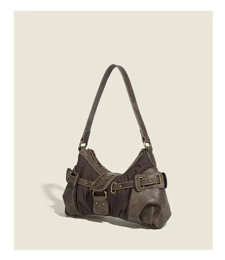 Slouchy brown Y2K underarm purse with buckle details and zipper closure on a beige background