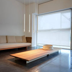 Three pendant tube lights with a modern style, featuring long cylindrical shapes in white colours, suspended from the ceiling of a living room.